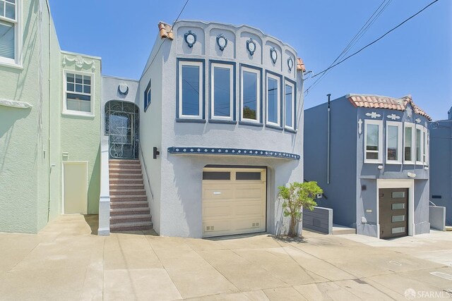 65 Danton St, San Francisco, CA 94112 - view of front of home featuring stucco siding, an attached garage, and driveway