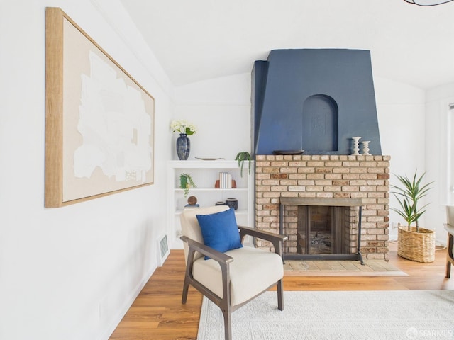 65 Danton St, San Francisco, CA 94112 - living area with vaulted ceiling, wood finished floors, and a brick fireplace