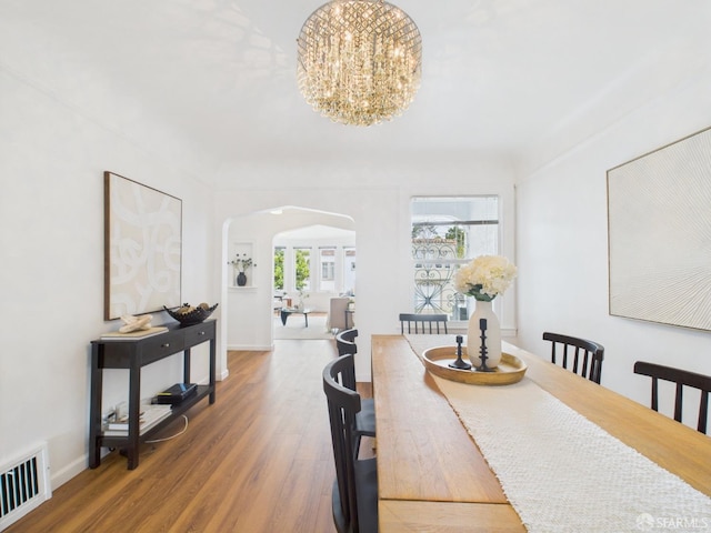 65 Danton St, San Francisco, CA 94112 - dining space featuring arched walkways, a chandelier, and wood finished floors