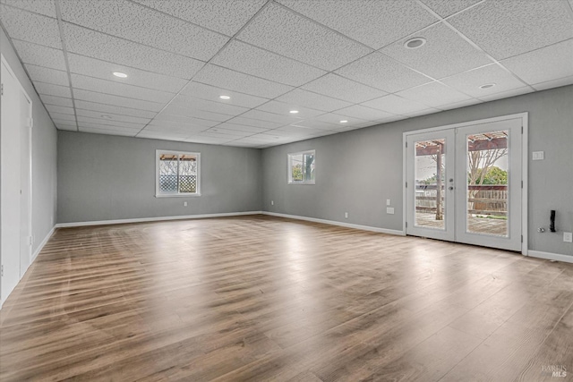 unfurnished room featuring french doors, baseboards, and wood finished floors