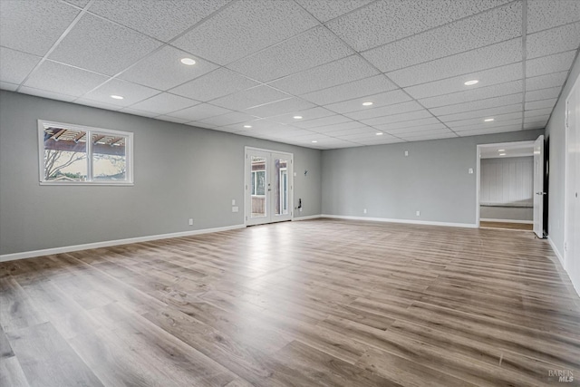 unfurnished room with a wealth of natural light, baseboards, and wood finished floors