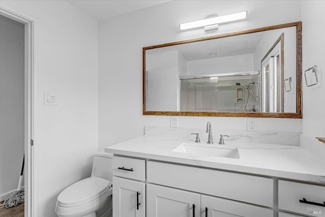 bathroom featuring a stall shower, vanity, and toilet