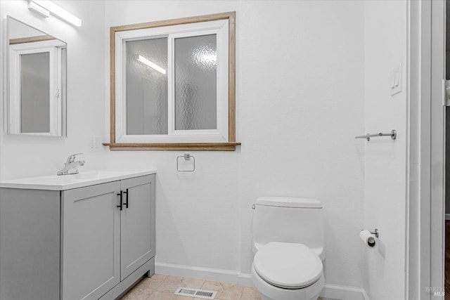 bathroom featuring visible vents, toilet, vanity, tile patterned flooring, and baseboards