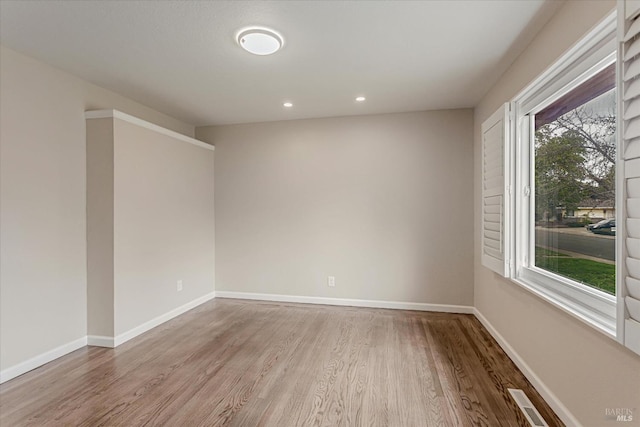 unfurnished room with visible vents, baseboards, wood finished floors, and recessed lighting