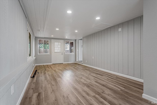 interior space featuring attic access, baseboards, and wood finished floors