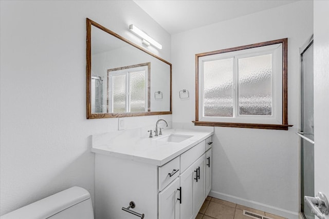 bathroom with toilet, tile patterned floors, baseboards, and vanity