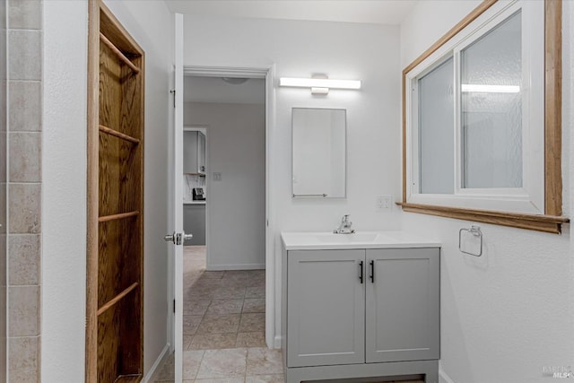 bathroom featuring vanity, baseboards, and tile patterned floors