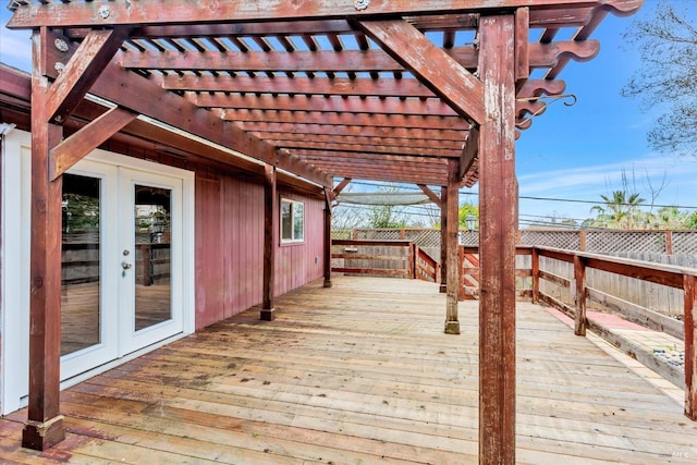 wooden deck with a fenced backyard, a pergola, and french doors