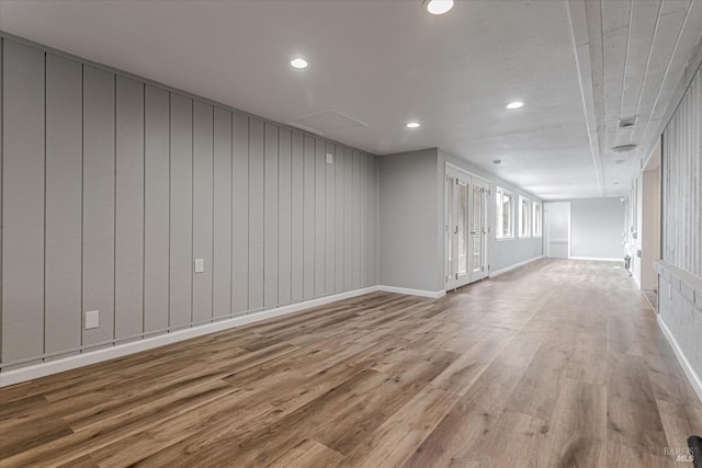 unfurnished room with baseboards, wood finished floors, and recessed lighting