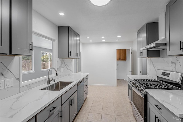 kitchen featuring appliances with stainless steel finishes, backsplash, a sink, and gray cabinetry