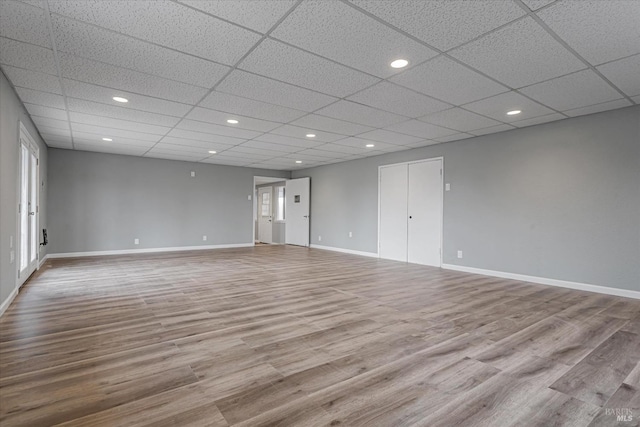 spare room featuring recessed lighting, a paneled ceiling, baseboards, and wood finished floors