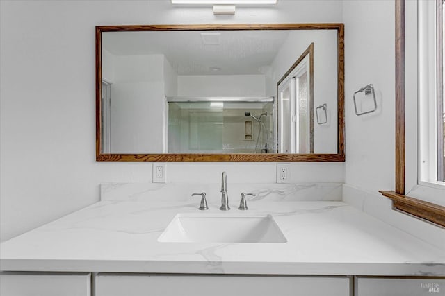 full bathroom with a shower stall and vanity