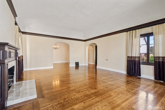 unfurnished living room with wood-type flooring and crown molding