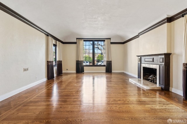 unfurnished living room featuring crown molding, dark wood-type flooring, and a premium fireplace