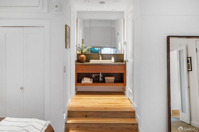 corridor featuring a sink and wood finished floors