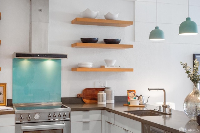 kitchen featuring open shelves, high end stainless steel range oven, white cabinetry, a sink, and wall chimney range hood