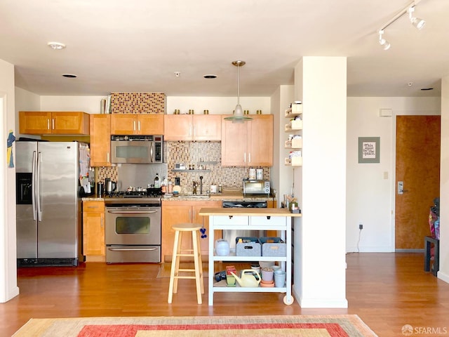81 Frank Norris St Unit 501, San Francisco, CA 94109 - kitchen featuring appliances with stainless steel finishes, wood finished floors, backsplash, pendant lighting, and a sink