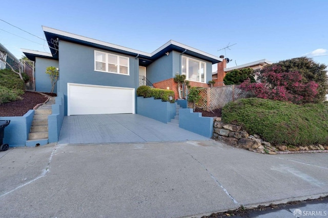 view of front of house featuring brick siding, stucco siding, driveway, and a garage