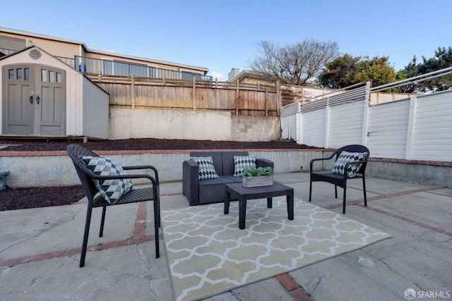 view of patio featuring an outbuilding, a fenced backyard, a shed, and an outdoor hangout area