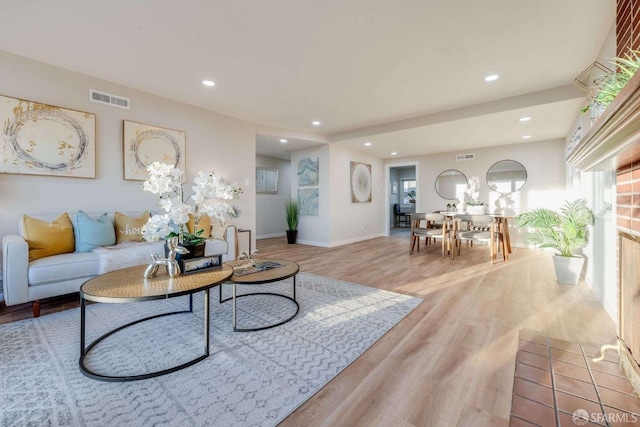 living area featuring light wood finished floors, visible vents, recessed lighting, and baseboards