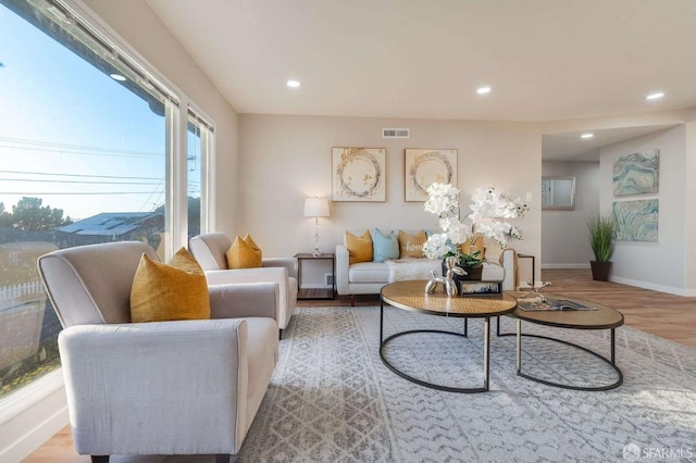 living area featuring recessed lighting, wood finished floors, visible vents, and baseboards