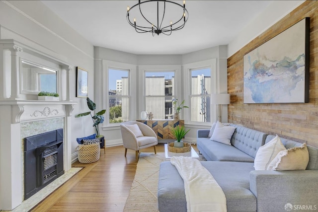 living room with a notable chandelier, a tile fireplace, and hardwood / wood-style flooring