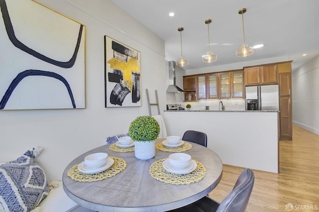 dining space with light hardwood / wood-style flooring and sink