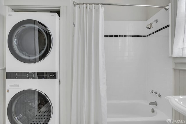 interior space featuring stacked washer / dryer, sink, and shower / bathtub combination with curtain