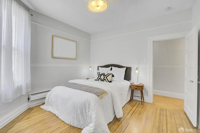 bedroom featuring a baseboard radiator and hardwood / wood-style flooring