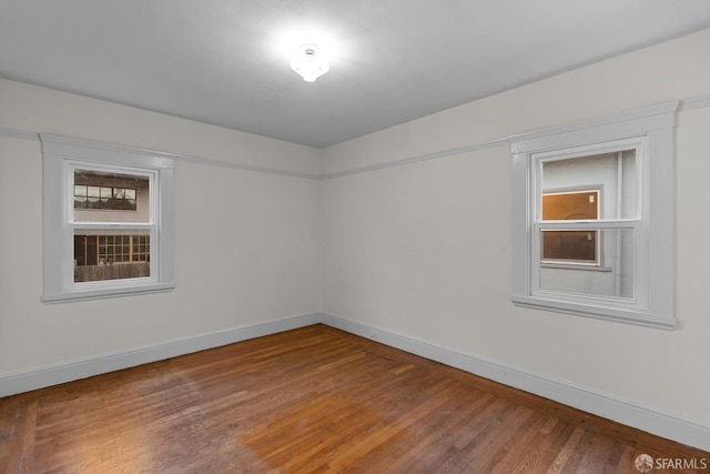 spare room featuring wood finished floors and baseboards