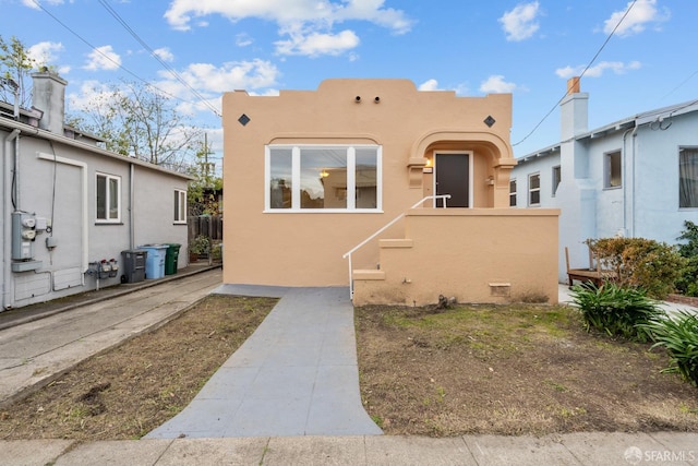 pueblo-style house featuring stucco siding