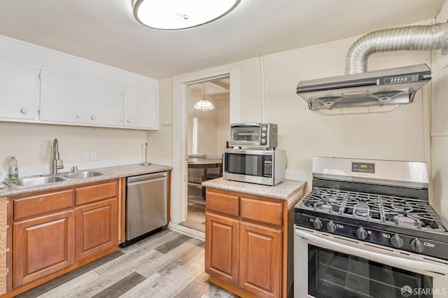 3233 Ellis St, Berkeley, CA 94703 - kitchen with stainless steel appliances, a sink, light wood-style floors, light countertops, and range hood