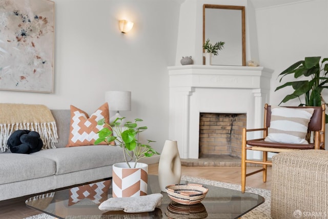 living room with a fireplace with raised hearth and wood finished floors