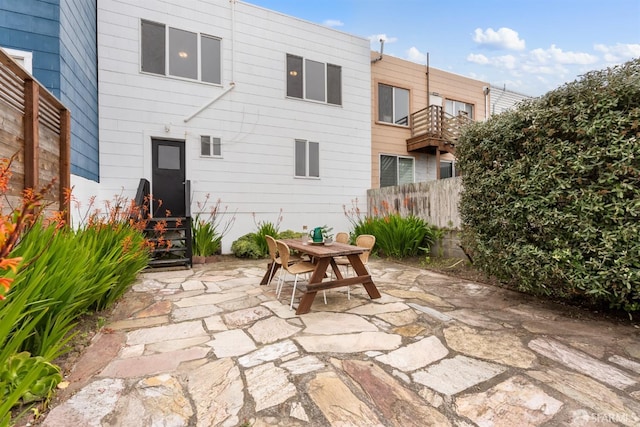 view of patio featuring outdoor dining area and fence