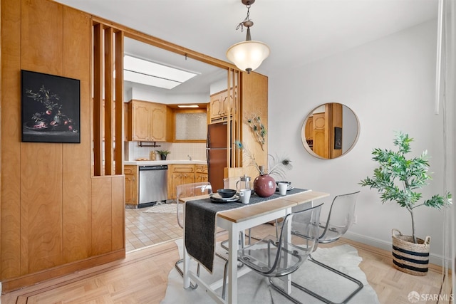 kitchen with pendant lighting, tasteful backsplash, light countertops, freestanding refrigerator, and dishwasher