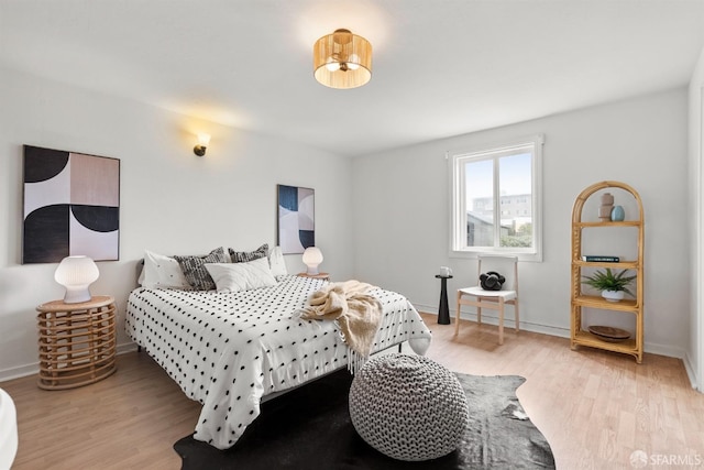 bedroom with baseboards and wood finished floors