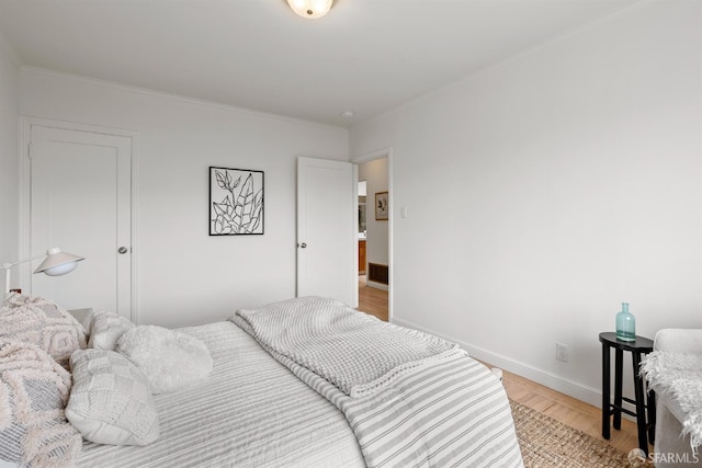 bedroom featuring light wood-style flooring and baseboards