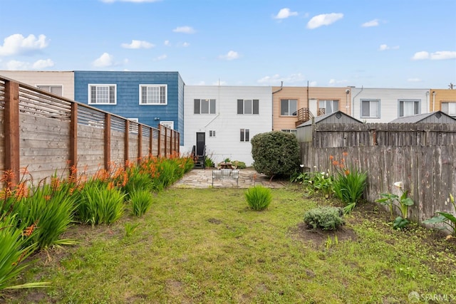 rear view of house featuring a patio area, a fenced backyard, and a yard