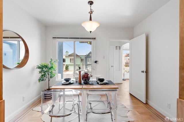 dining area with baseboards and arched walkways