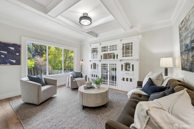 living area with coffered ceiling, wood finished floors, baseboards, beamed ceiling, and crown molding