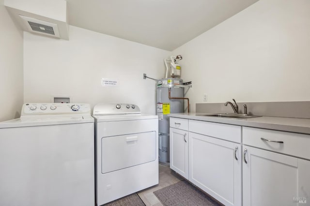 laundry room with cabinets, independent washer and dryer, sink, and water heater