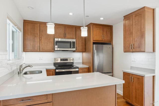 kitchen featuring sink, decorative backsplash, a wealth of natural light, appliances with stainless steel finishes, and decorative light fixtures