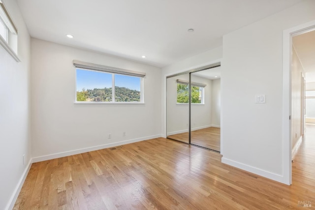 unfurnished bedroom featuring a closet and light hardwood / wood-style floors