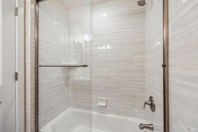 bathroom featuring bath / shower combo with glass door