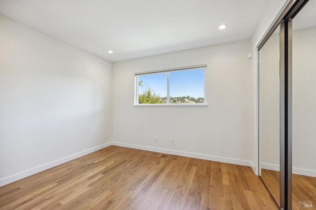 unfurnished bedroom featuring a closet and light wood-type flooring