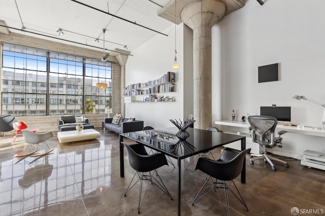 dining room with ornate columns and concrete flooring