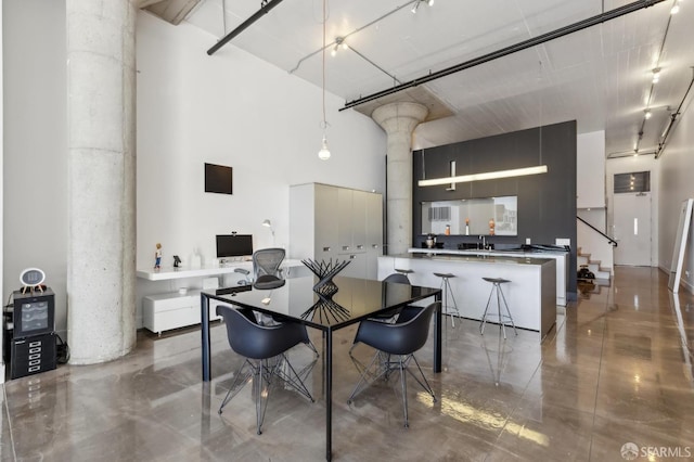 dining area featuring sink and a towering ceiling