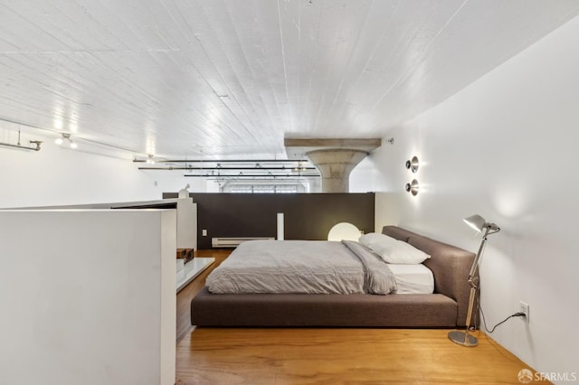 bedroom featuring hardwood / wood-style floors and baseboard heating