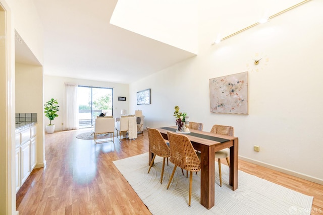 dining room featuring light wood-type flooring and baseboards