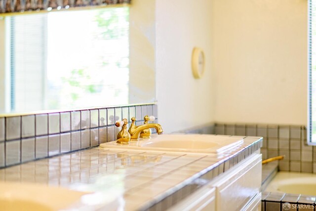 full bath with a bath and vanity